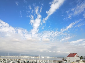 Ein Yachthafen mit zahlreichen angestaubten Booten unter einem teils bewölkten Himmel.