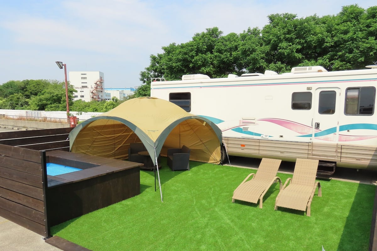 Un espace de camping équipé d’une tente, de chaises longues et d’un bain à remous.