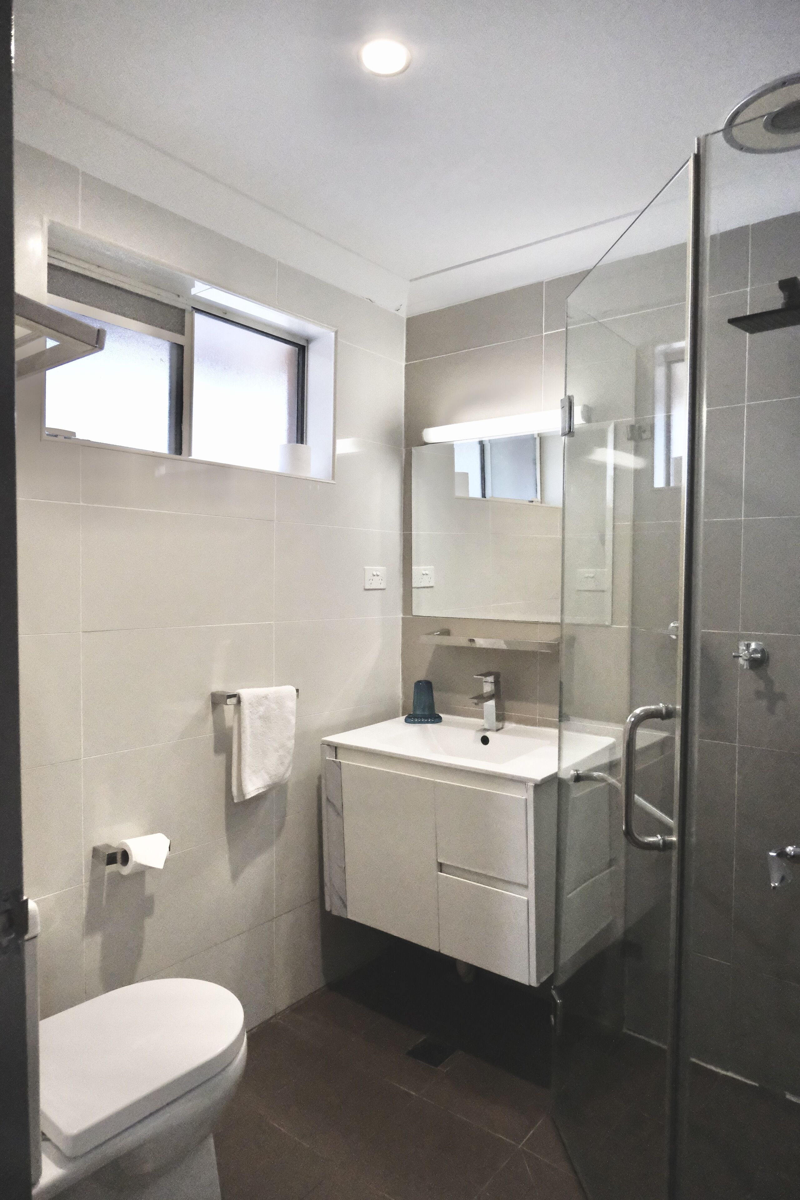 A modern bathroom with a toilet, sink, and shower.