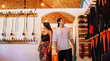 A room with a wooden ceiling, a wall-mounted rack with various items, and a display of shoes.