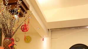 A reception area with a stone wall, a chalkboard menu, and a wooden reception desk. - Love in Hualien (Hualien City)