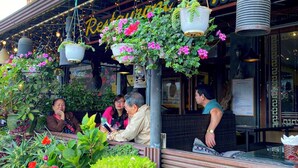 An outdoor seating area with hanging planters and a sign reading "Restaurant Coffee". - Sapa Lake View Hotel (Sa Pa)