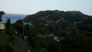 A coastal road with houses on a hillside, overlooking the sea. - Top Ranking Guesthouse (Speyside)