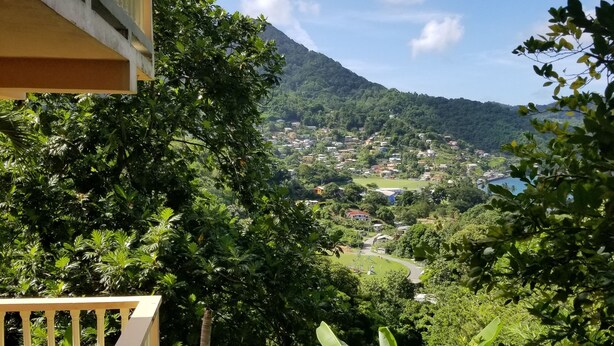 A balcony with a view of a lush green landscape, a mountain in the distance, and a body of water. - Grand View Guesthouse (Speyside)