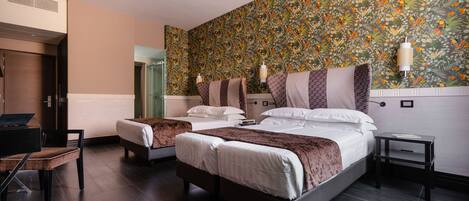 A hotel room with two beds, a desk, and a chair.