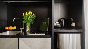 A modern kitchen with a stainless steel sink, a coffee machine, and a book titled "In cucina OGGI Dietetica". - Unica Suites Rome (Rome)