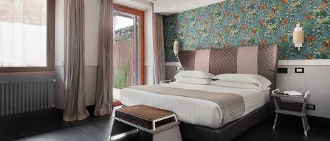 Une chambre moderne avec un grand lit, une table de chevet, une commode et une fenêtre avec des rideaux.