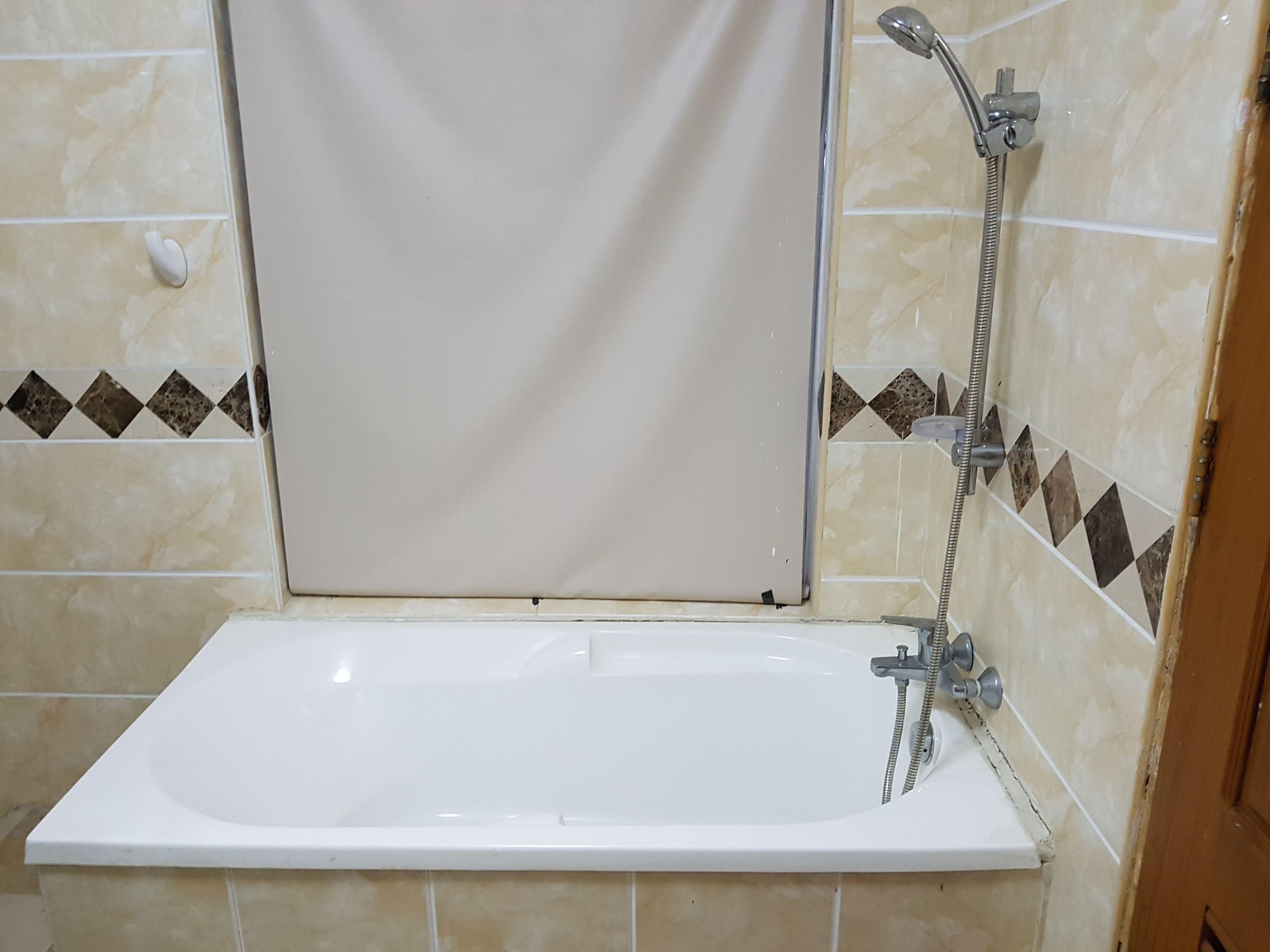 Ein Badezimmer mit Badewanne, Dusche und Fliesen.