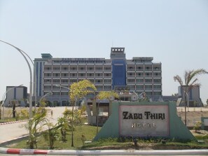 Hotel Zabu Thiri, un edificio grande con varios pisos y un cartel llamativo al frente.