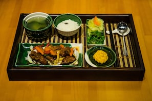 A tray with various dishes including meat, vegetables, rice, and soup.