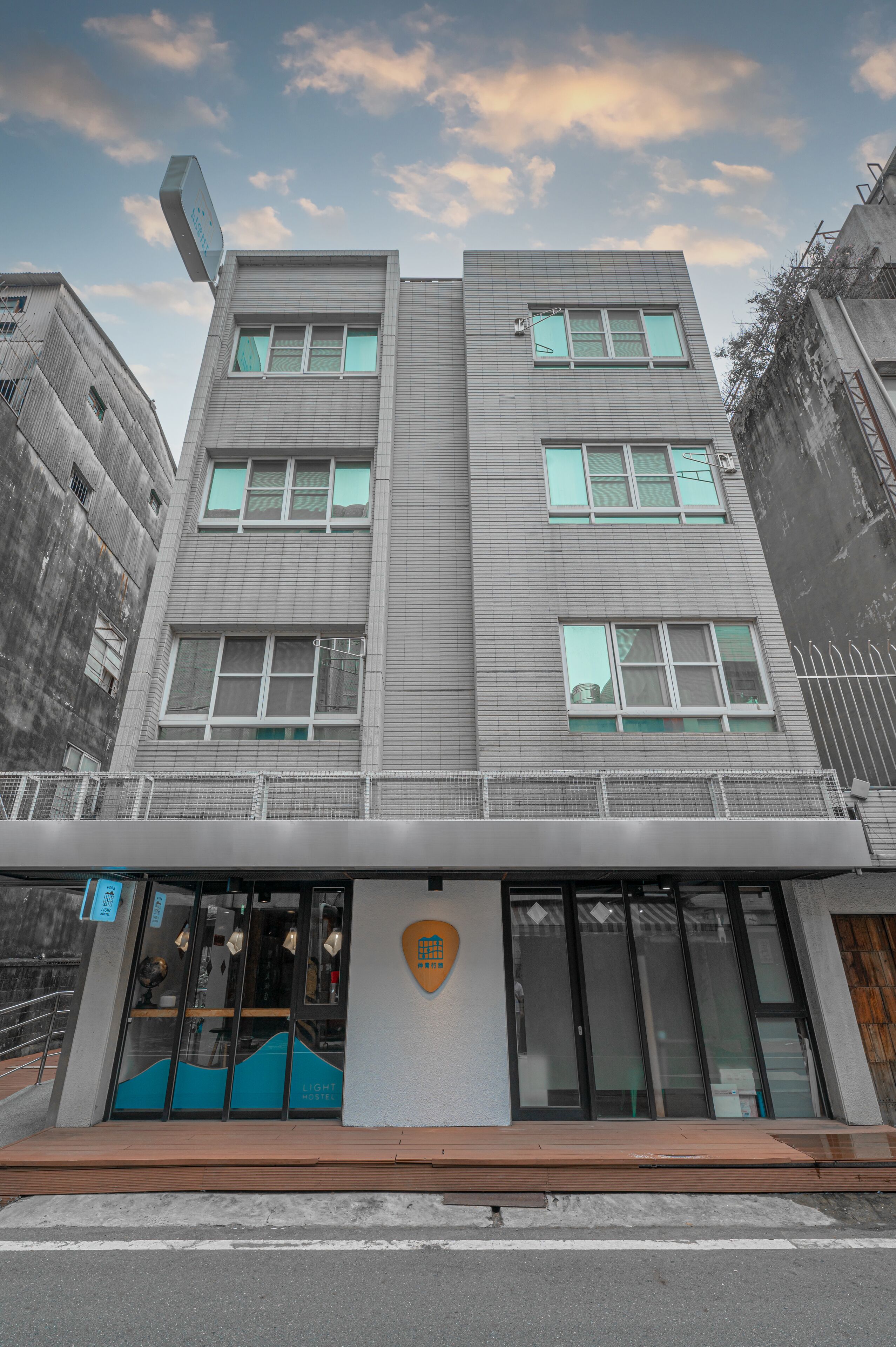 A modern building with a flat roof, large windows, and a logo on the facade.
