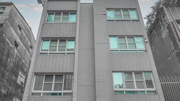 A modern building with a flat roof, large windows, and a logo on the facade.
