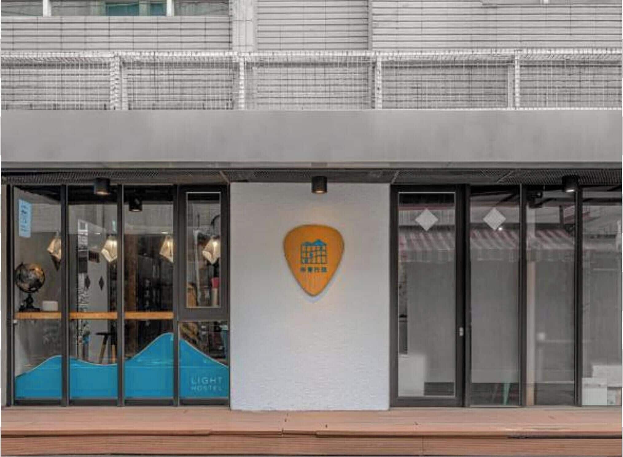 A building with a modern design, featuring a large glass entrance and a logo on the facade.