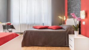 Een moderne slaapkamer met een bed, bureau en stoel.
