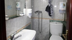 Un baño con lavamanos, inodoro y ducha.