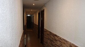 Un pasillo estrecho con suelo de madera y un diseño decorativo en la pared.