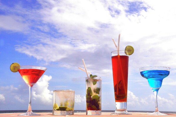 Four different drinks on a table with a clear sky in the background. - The Beach Cabanas (Koggala)