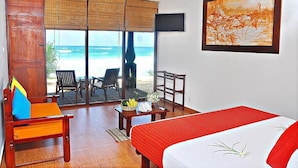 Habitación de hotel con cama, escritorio, silla y vista a la playa.
