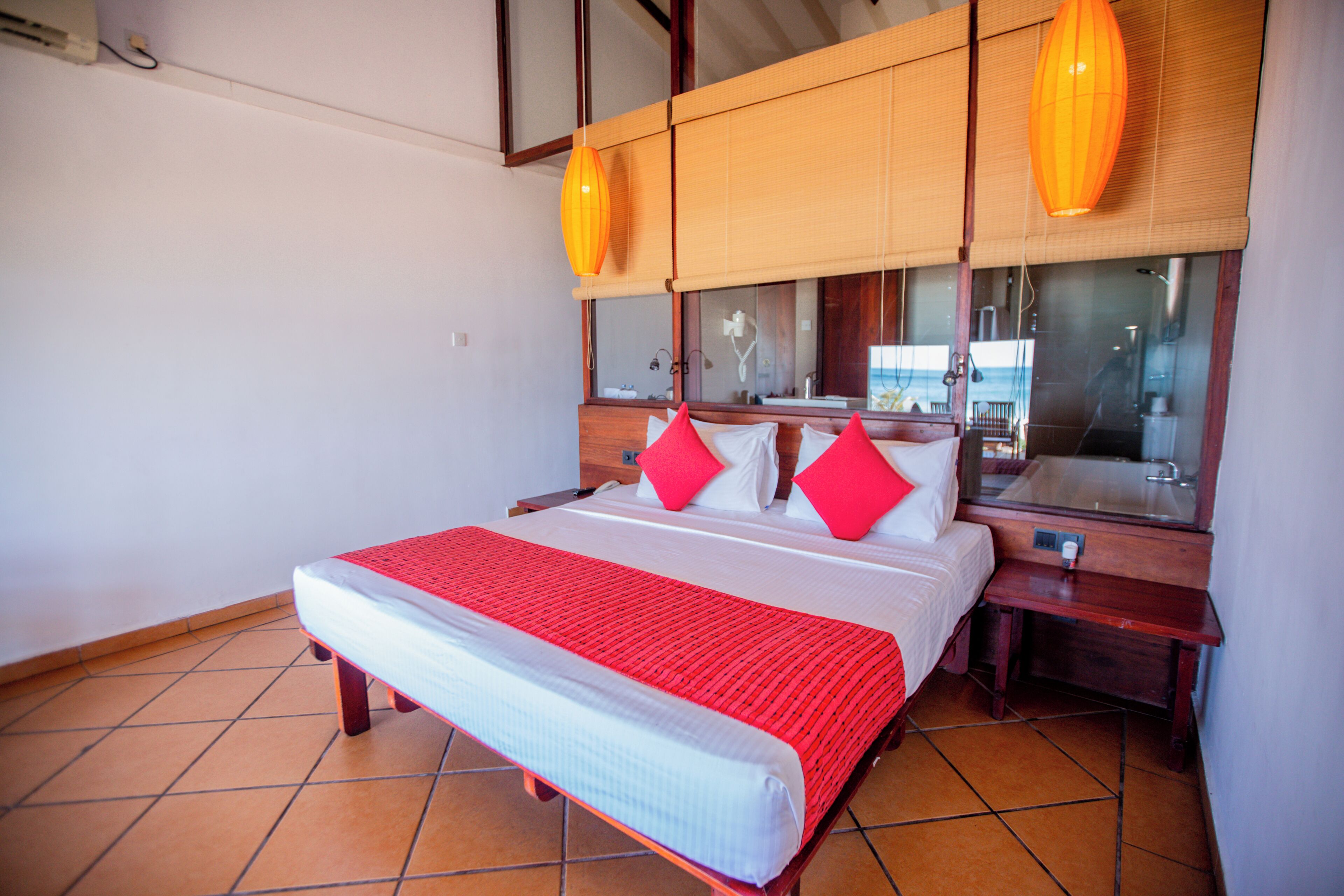 A hotel room with a large bed, wooden headboard, and two bedside tables.