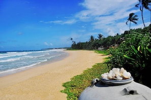 A beach with a clear view of the ocean, a sandy shore, and some greenery. - The Beach Cabanas (Koggala)