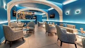 A modern lounge area with seating, a bar, and a television screen. - Behotelisboa (Lisbon)