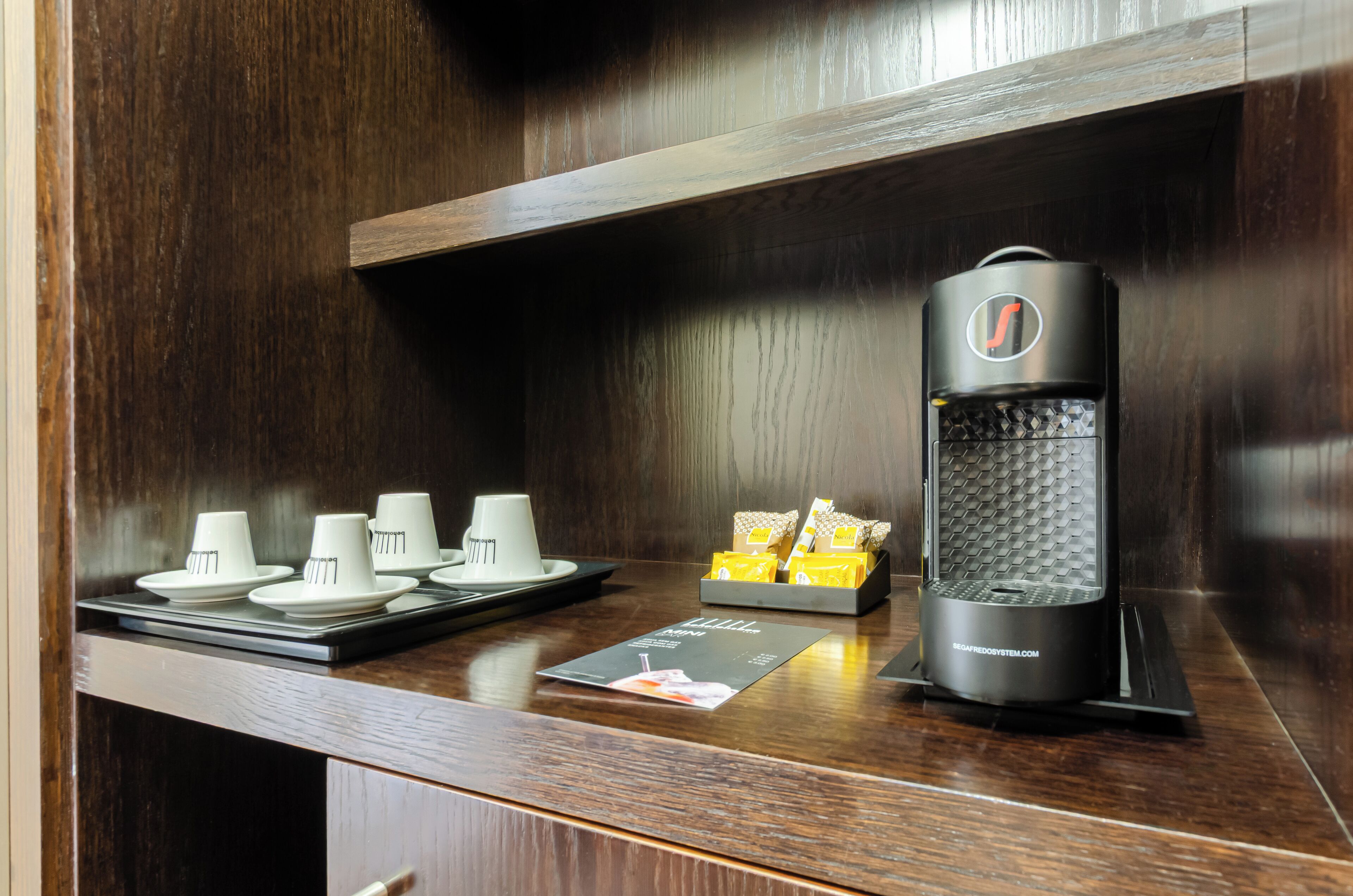 Una estación de café con una máquina de café, tazas y un menú.