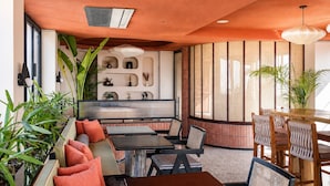 A modern interior with a seating area, a dining table, and decorative shelves. - My Downtown - The Red Pier (Udaipur)