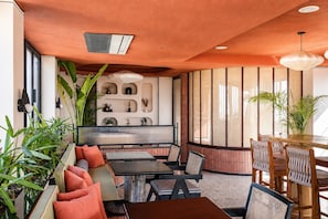A modern interior with a seating area, a dining table, and decorative shelves. - My Downtown - The Red Pier (Udaipur)