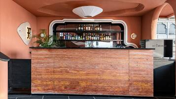 A bar area with a wooden counter and a variety of bottles.