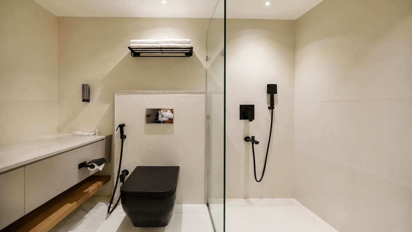 A modern bathroom with a shower, toilet, and a towel rack.