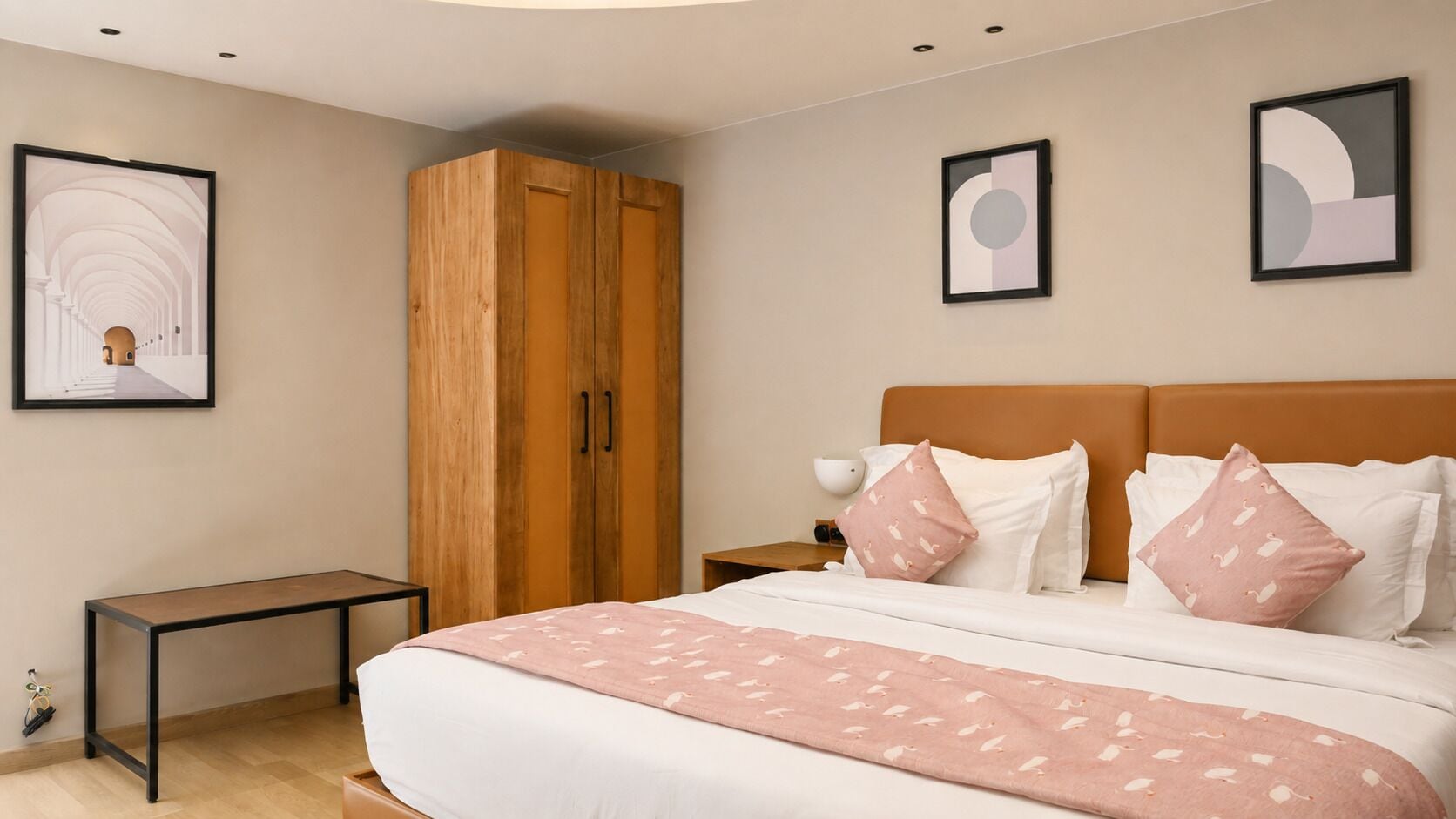 Un dormitorio con una cama, un armario de madera, una mesita de noche y un cuadro enmarcado en la pared.
