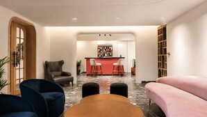 A modern interior with a seating area, a bar, and a bookshelf. - My Downtown - The Red Pier (Udaipur)