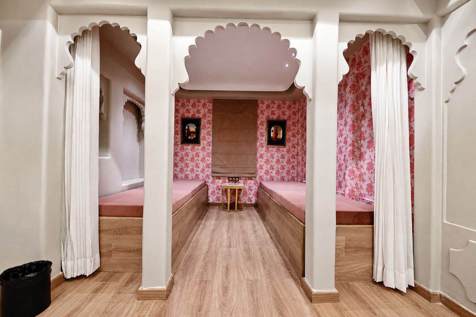 A room with a central seating area, two side tables, and a small table in the middle.