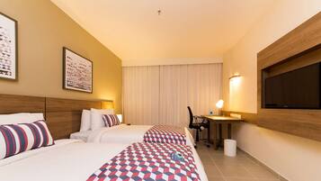 Habitación de hotel con dos camas, un escritorio, una silla, un televisor y una ventana con cortinas.