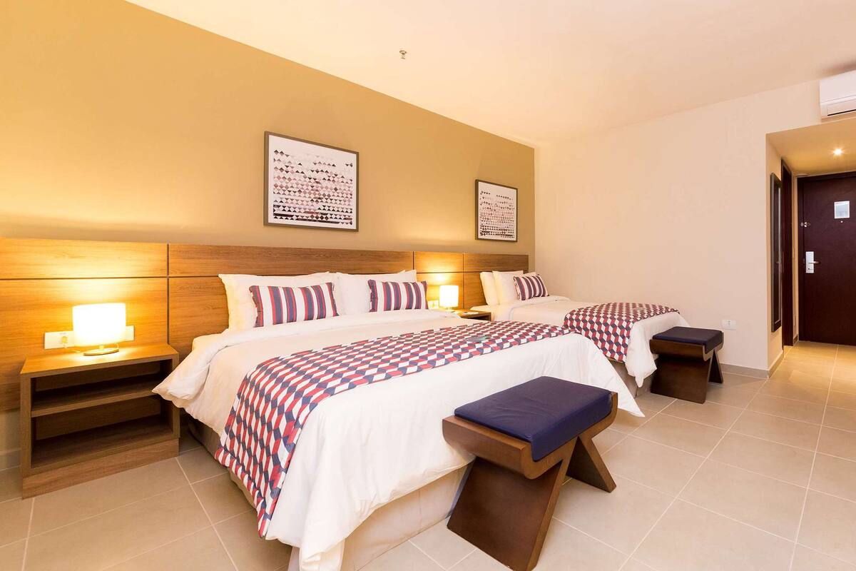 Une chambre d’hôtel avec deux lits, un bureau et une salle de bain.