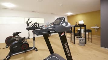 A gym with exercise equipment, including a treadmill and stationary bikes.