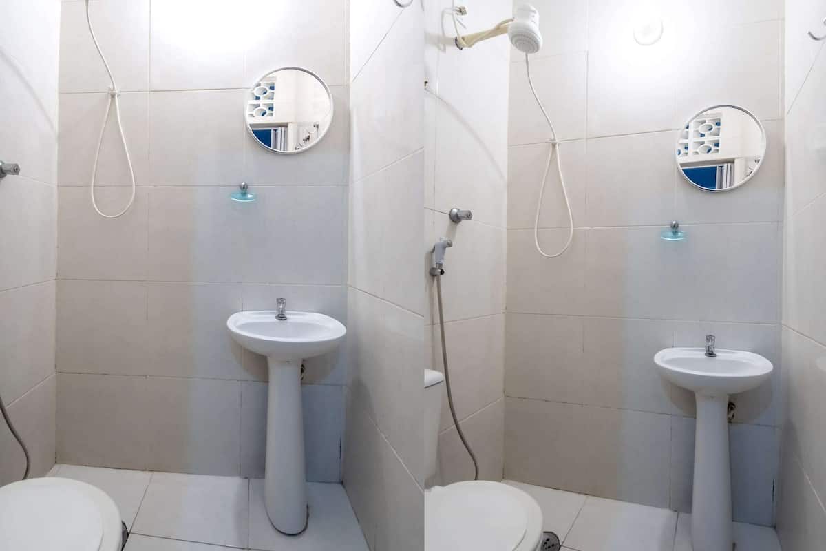 A bathroom with two sinks, a toilet, and a shower.