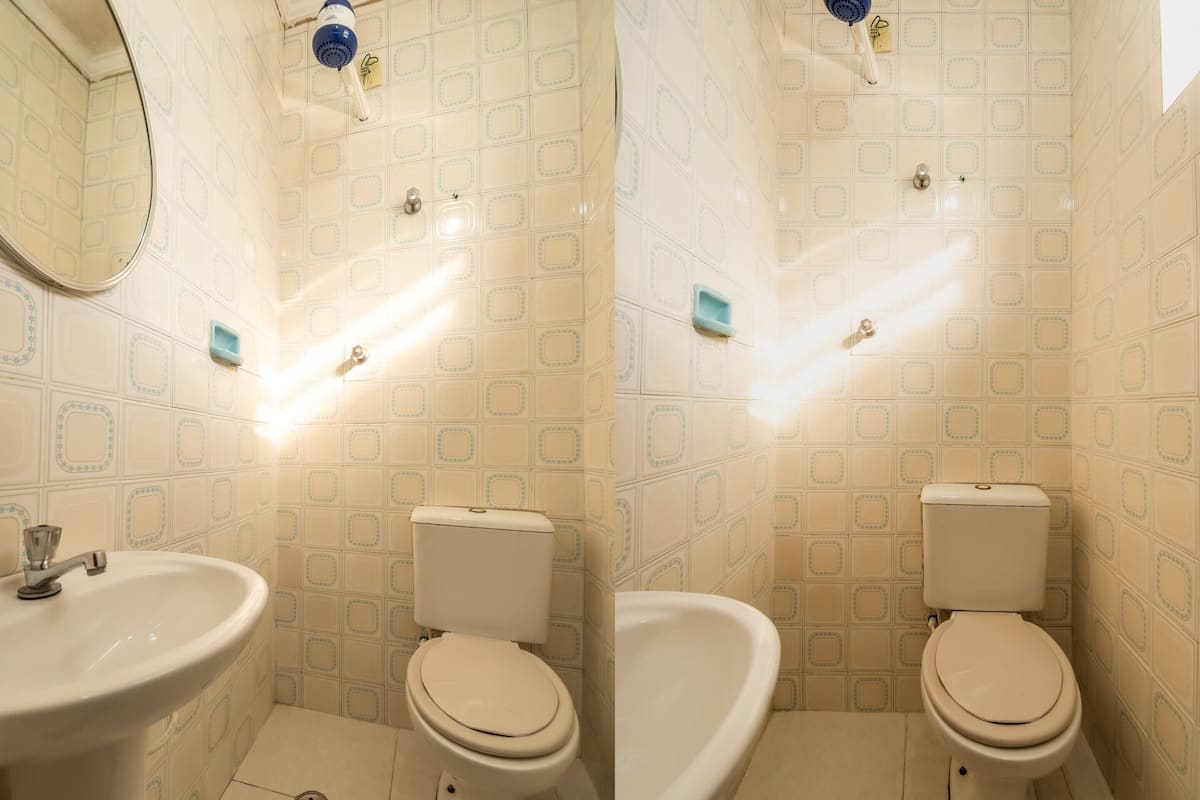 A bathroom with a sink, toilet, and mirror.