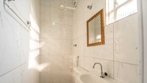 Un baño con inodoro, lavabo y ducha.