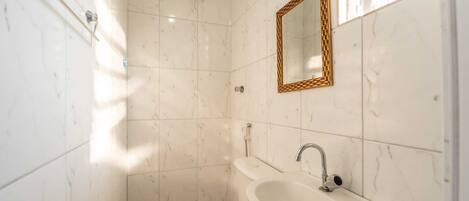 A bathroom with a toilet, sink, and shower.