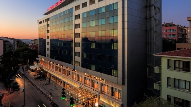 A modern hotel with a prominent "CONGRESIUM" sign, multiple floors, and a well-lit entrance area.