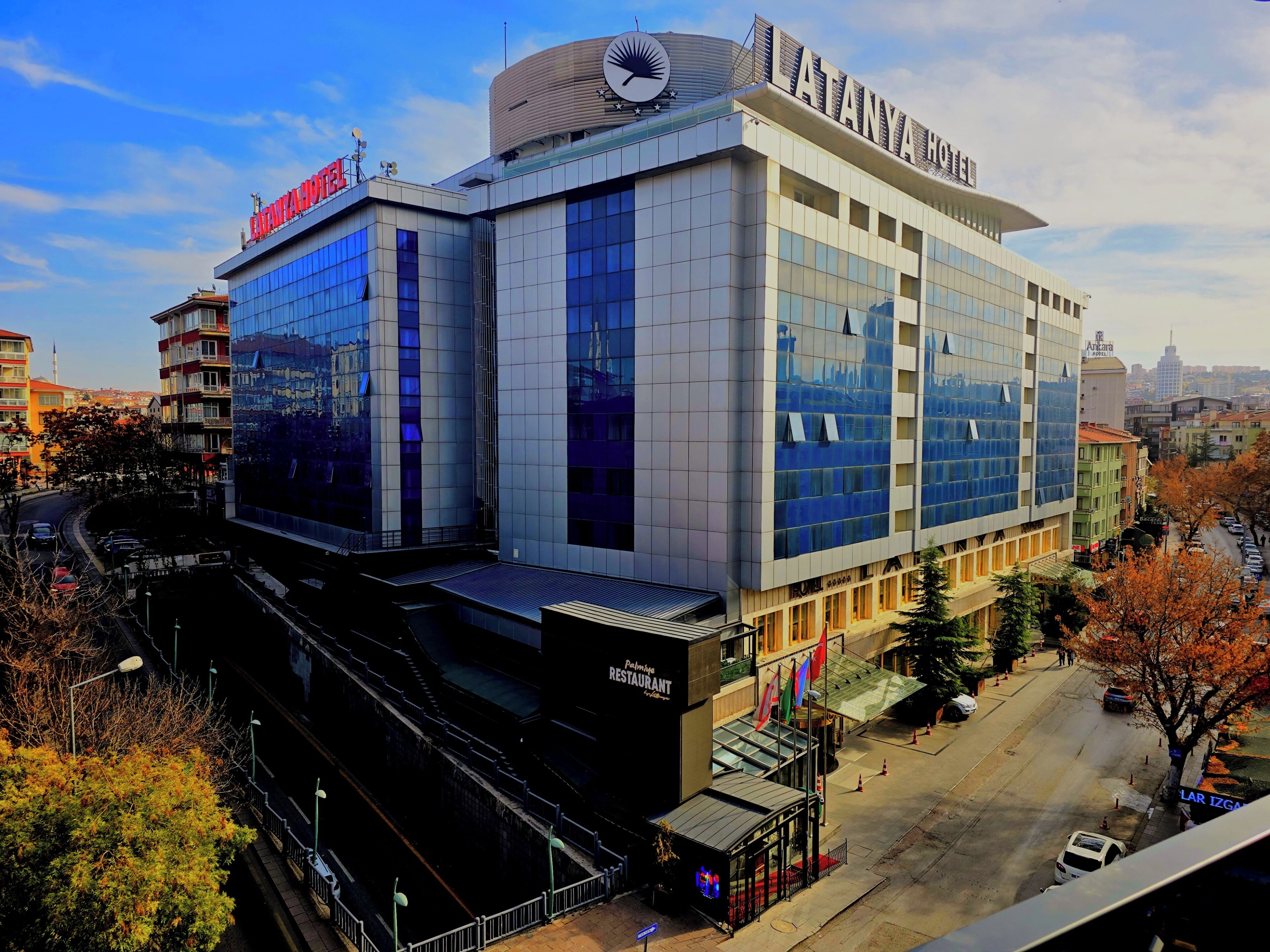 A modern hotel with a prominent sign, multiple floors, and a restaurant.
