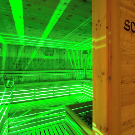 A sauna room with wooden walls and a sign that reads "Sauna".