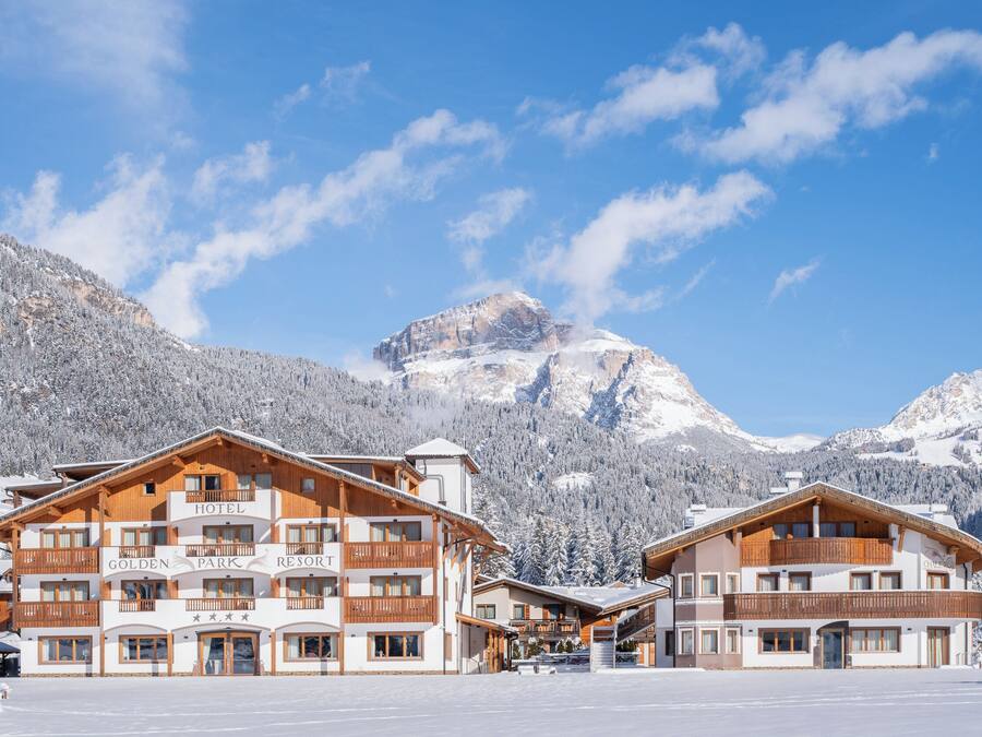 A hotel with multiple balconies and a ski resort sign.