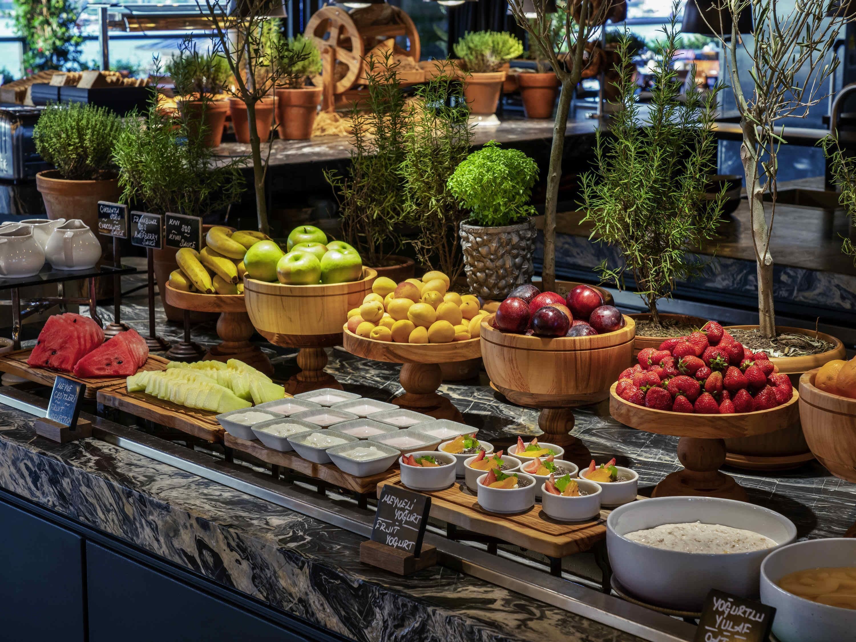 A fruit and yogurt display with various fruits and bowls of yogurt.