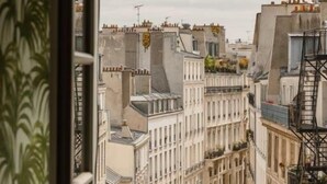 A view from a balcony overlooking a cityscape with buildings and a fire escape. - Hôtel Providence (Paris)