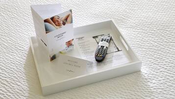 A Courtyard® StayWell® room sign-in box with a remote control and a welcome card.