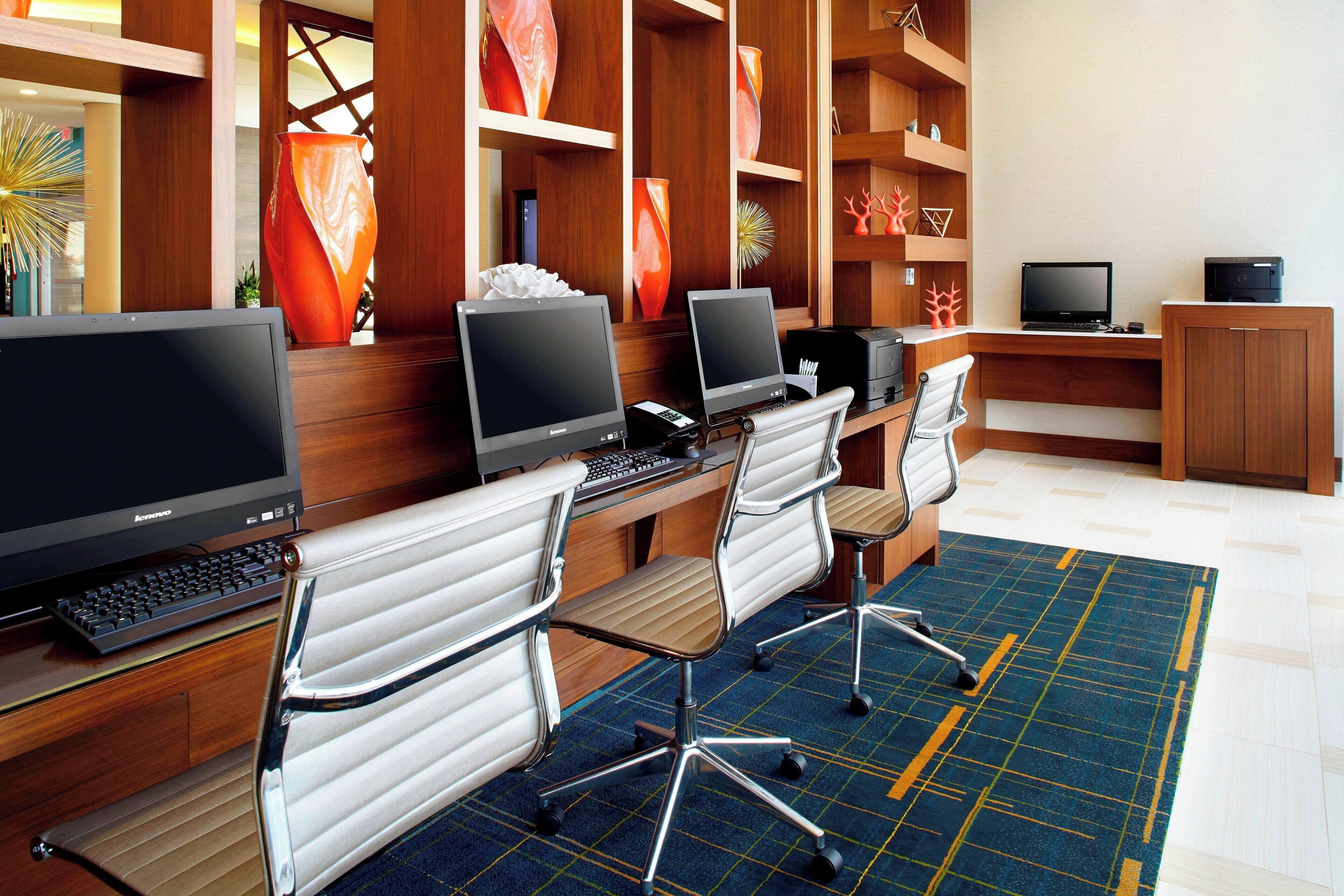 A modern office space with multiple computer workstations, ergonomic chairs, and decorative vases.