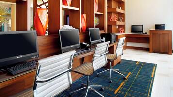A modern office space with multiple computer workstations, ergonomic chairs, and decorative vases.