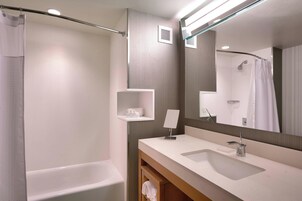 Un baño moderno con bañera, lavabo y espejo.